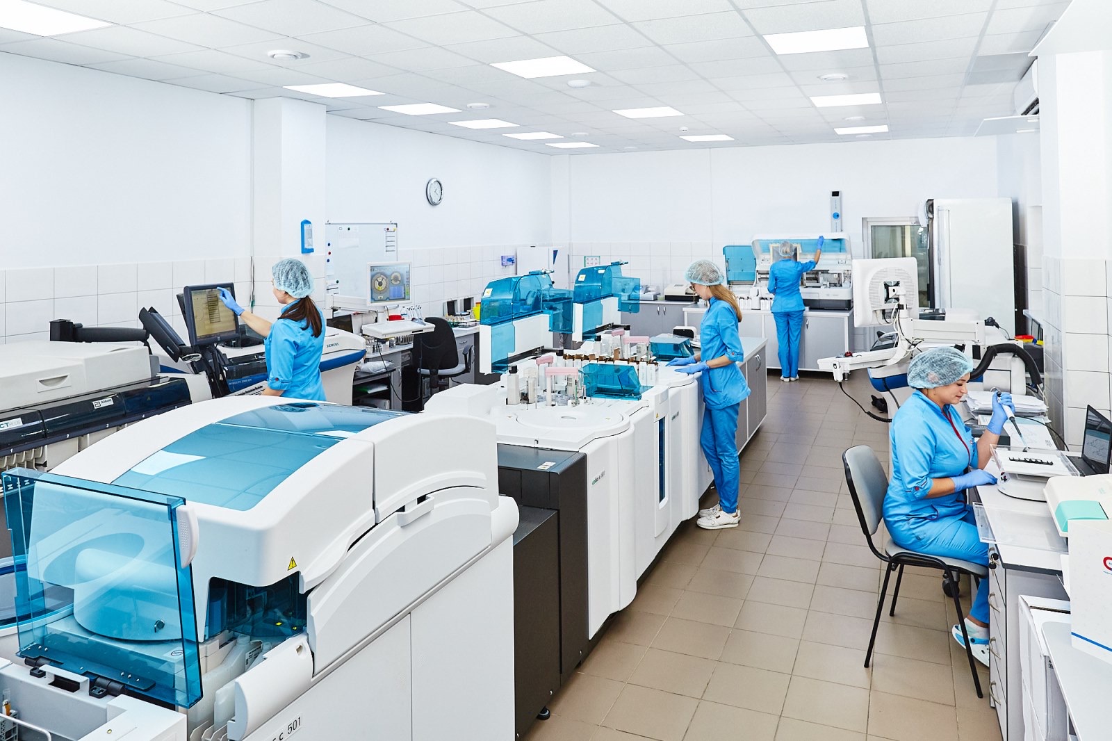 Analysts working at automated instruments on a laboratory floor